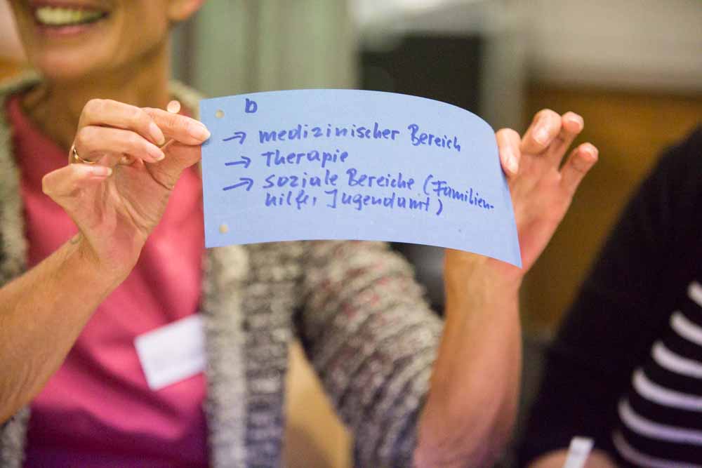 Eine Teilnehmerin zeigt ihr Notizen beim Bürgerdialog 