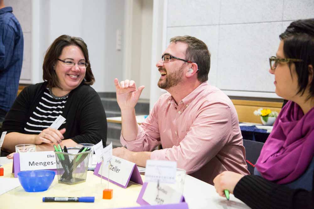 Participants laugh with each other at the citizen dialogue 