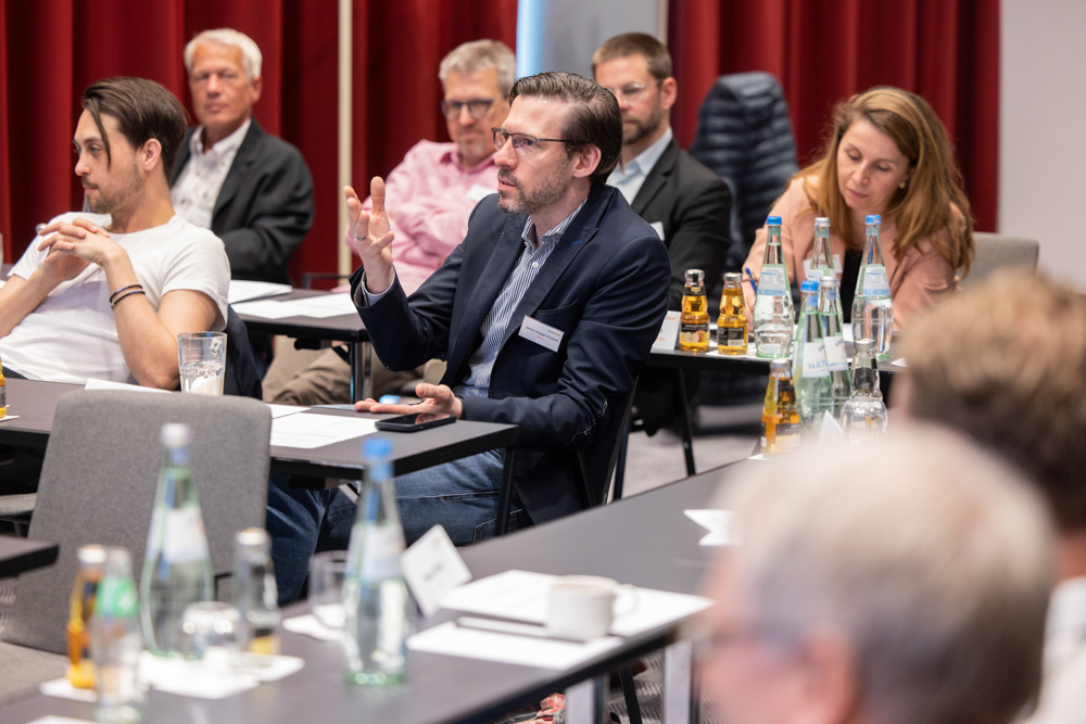 Die Teilnehmer des OnkoRats 2023 von Iomedico diskutieren lebhaft in einem Seminar miteinander. Fotografische Begleitung durch Martin Leissl Eventfotografie.