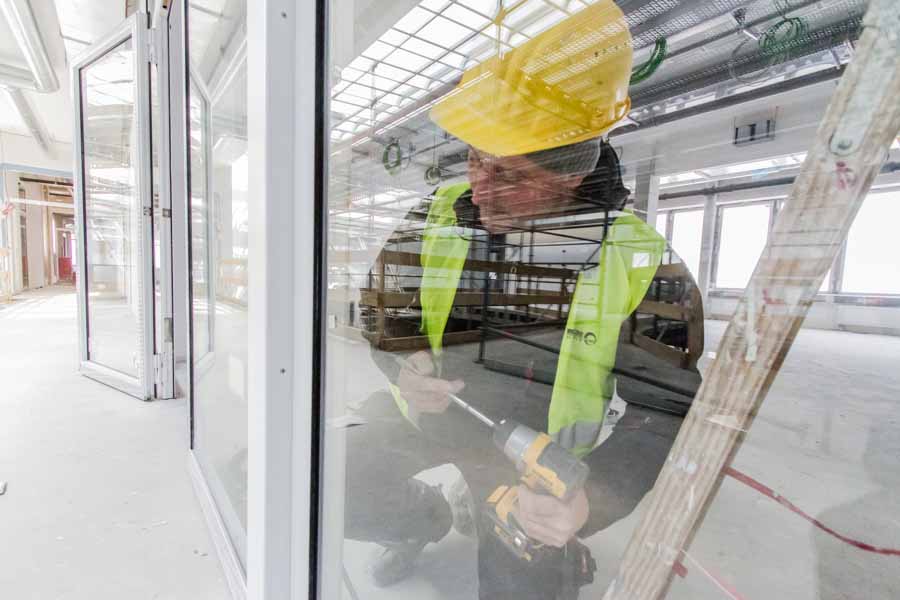 Ein Handwerker montiert Glastüren im Neubau des Clariant Forschungszentrums CIC im Industriepark Frankfurt Höchst.
