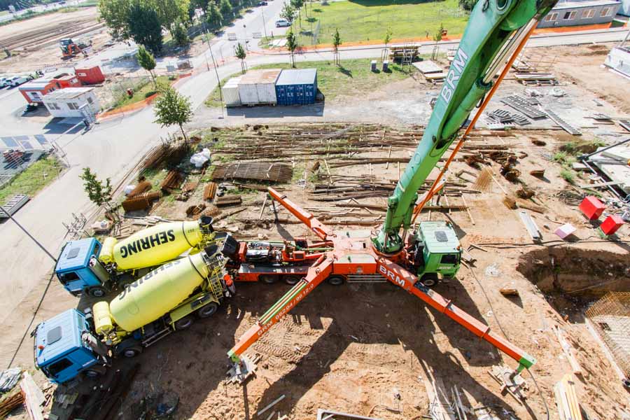 Two concrete mixers unload concrete for the new Clariant Research Center building, which is then pumped onto the construction site.