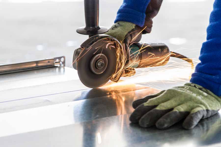 A craftsman cuts a sheet of steel with a flex on the Clariant Innovation Center construction site