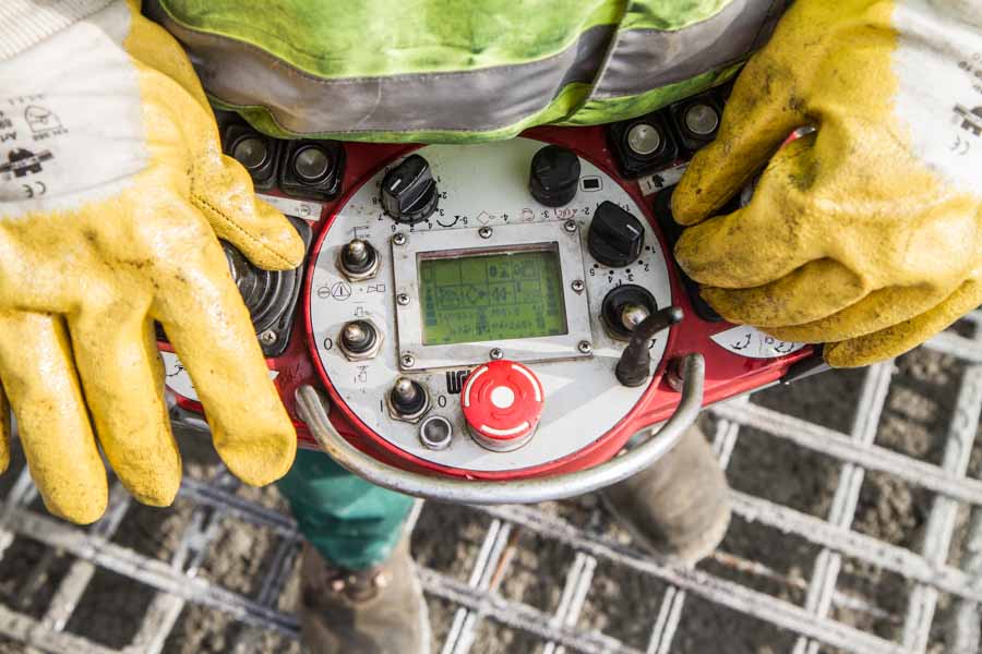 A fitter operates the remote control of a concrete pump on the Clariant Innovation Center construction site