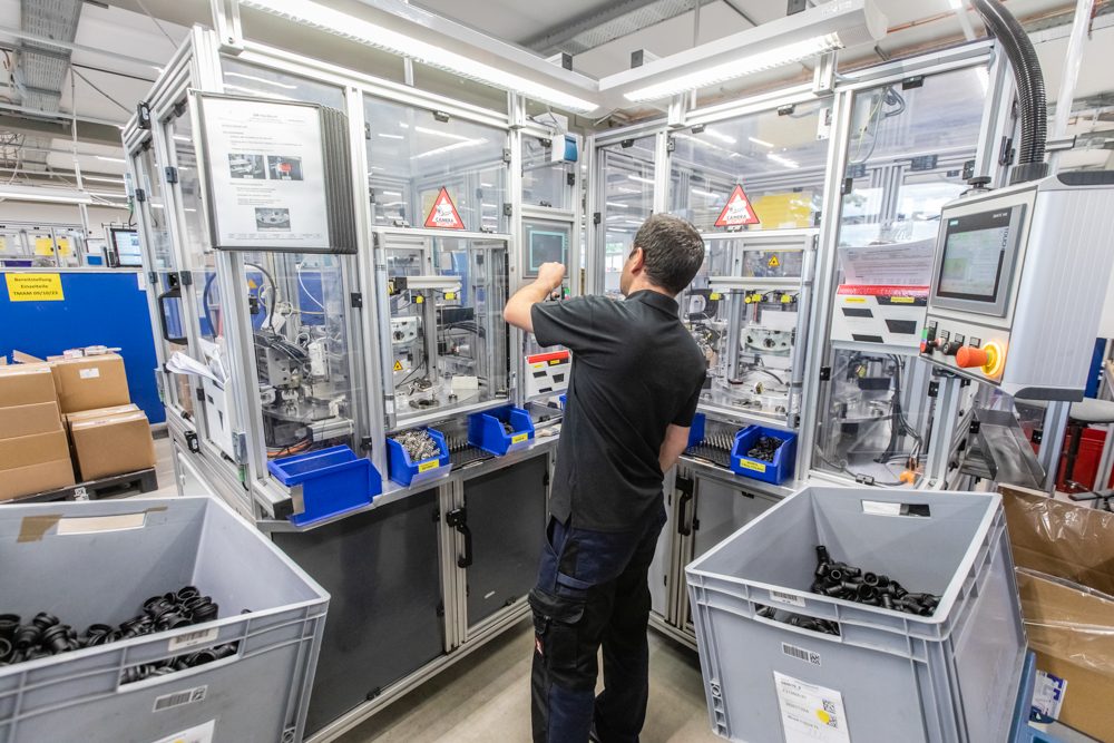 Fotoreportage bei VOSS Automotive Gründau: Enge Zusammenarbeit mit dem Marketing-Team. Ein Mitarbeiter an einer Maschine im Fokus