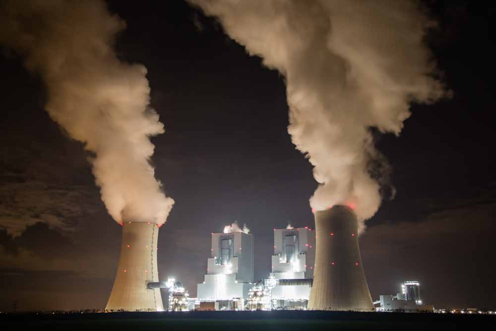 Chimneys emit vapor into the night sky at the Garzweiler lignite power plant, operated by RWE AG, in Garzweiler, Germany