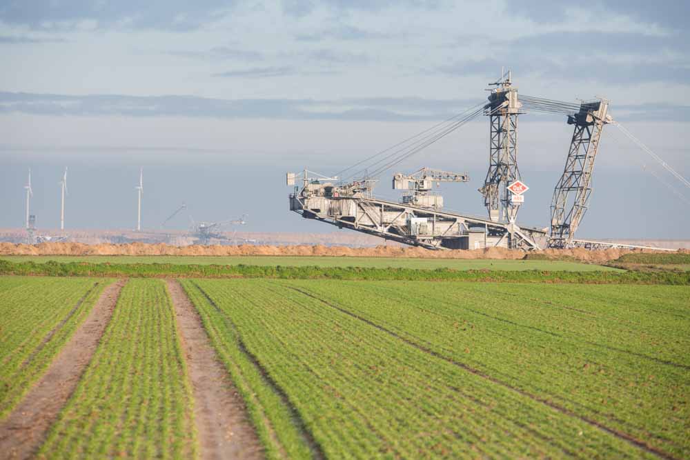 A giant excavator operates beyond agricultural land at the Garzweiler open cast lignite mine, operated by RWE AG, in Garzweiler, Germany.
